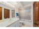 Bathroom featuring a shower and tub combo with a sliding glass door, a vanity, and wood design at 1408 San Cristobal Ave # 4, Punta Gorda, FL 33983