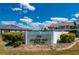 A welcome sign for Maine Way Villas featuring lush green bushes under a partly cloudy blue sky at 1408 San Cristobal Ave # 4, Punta Gorda, FL 33983