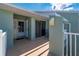 A front porch featuring a storm door, outside lantern, beige painted concrete, and white railings at 1408 San Cristobal Ave # 4, Punta Gorda, FL 33983
