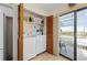 Efficient laundry area with modern white washer and dryer, plus shelving, and balcony access via sliding glass doors at 1408 San Cristobal Ave # 4, Punta Gorda, FL 33983