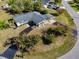 Aerial view of charming home featuring a well-kept lawn, mature trees, and a curved driveway at 146 Francis Ne Dr, Port Charlotte, FL 33952