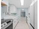 Galley kitchen with modern white cabinetry, stainless steel appliances, and stone countertops at 146 Francis Ne Dr, Port Charlotte, FL 33952