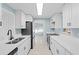 Modern kitchen featuring white cabinetry, stone countertops, and stainless steel appliances at 146 Francis Ne Dr, Port Charlotte, FL 33952
