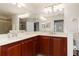 Spacious bathroom featuring a dual-sink vanity with dark wood cabinets, large mirror, and walk-in shower at 17094 Acapulco Rd # 312, Punta Gorda, FL 33955