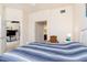 Comfortable bedroom with blue and white bedding, wicker chair, and doorway to en-suite bath and closet at 17094 Acapulco Rd # 312, Punta Gorda, FL 33955