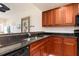 Modern kitchen featuring wood cabinetry and stainless steel dishwasher at 17094 Acapulco Rd # 312, Punta Gorda, FL 33955