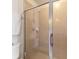 Modern walk-in shower featuring tan tiled walls, glass door, and updated shower head at 17094 Acapulco Rd # 312, Punta Gorda, FL 33955