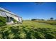 Spacious backyard with lush green grass, waterway, and outdoor seating area at 17408 Malarky Ln, Punta Gorda, FL 33955
