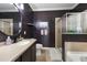A bathroom offers a sink vanity, a separate shower, a bathtub, and tile flooring at 17408 Malarky Ln, Punta Gorda, FL 33955