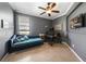 Stylish bedroom featuring a comfortable blue daybed, modern desk, and elegant tile flooring at 17408 Malarky Ln, Punta Gorda, FL 33955