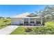 Charming single-story home featuring lush landscaping, a well-maintained lawn, and a metal roof at 17408 Malarky Ln, Punta Gorda, FL 33955