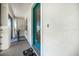 Welcoming front entrance with a teal door, textured walls, and a cozy welcome mat at 17408 Malarky Ln, Punta Gorda, FL 33955