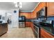 A kitchen showcases wood cabinets, stainless steel appliances, tile floors, and a refrigerator at 17408 Malarky Ln, Punta Gorda, FL 33955
