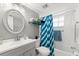 Well-lit bathroom with vanity, oval mirror, and shower-tub combo at 19505 Quesada Ave # F103, Port Charlotte, FL 33948