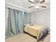 Comfortable bedroom with ceiling fan, natural light, and calming color scheme at 19505 Quesada Ave # F103, Port Charlotte, FL 33948