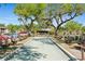 View of community bocce ball court surrounded by mature trees and benches for residents at 19505 Quesada Ave # F103, Port Charlotte, FL 33948