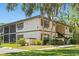 Inviting two-story condo building with brown shutters and lush green landscaping at 19505 Quesada Ave # F103, Port Charlotte, FL 33948