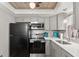 Charming kitchen featuring modern appliances, gray cabinetry, and wood ceiling at 19505 Quesada Ave # F103, Port Charlotte, FL 33948