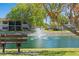 Scenic pond view with a fountain and a bench in a well-maintained community at 19505 Quesada Ave # F103, Port Charlotte, FL 33948