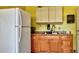 Kitchenette featuring a refrigerator, sink with wooden cabinets, and a microwave at 19505 Quesada Ave # L104, Port Charlotte, FL 33948