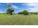 Expansive backyard featuring a well-maintained lawn and mature trees, offering plenty of space at 21 Manizaks Ave, Punta Gorda, FL 33983