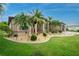 Inviting home exterior with lush tropical landscaping, accent lighting, and a well-maintained lawn at 21 Manizaks Ave, Punta Gorda, FL 33983