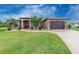 Charming single-story home with manicured lawn, tropical landscaping, and covered front entry at 21 Manizaks Ave, Punta Gorda, FL 33983