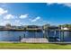 Lawn sloping down to the waterfront with wooden dock and boat lift at 21269 Edgewater Dr, Port Charlotte, FL 33952