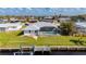 Backyard view of a waterfront house featuring a private boat dock and screened-in pool at 21269 Edgewater Dr, Port Charlotte, FL 33952