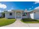 Inviting home front with white siding, manicured lawn, and a well-lit entryway at 21269 Edgewater Dr, Port Charlotte, FL 33952