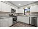 Well-lit kitchen with stainless steel appliances, grey countertops, and wood floors at 21269 Edgewater Dr, Port Charlotte, FL 33952