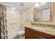 A bathroom featuring granite countertops, wood cabinets, a shower/tub combo, and neutral tile at 220 Coldeway Dr # 211, Punta Gorda, FL 33950
