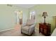 An armchair sits next to an end table and in front of an arched window in this light green bedroom at 220 Coldeway Dr # 211, Punta Gorda, FL 33950