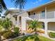Inviting condo exterior with landscaped yard, white railings, beige paint, and tropical foliage at 220 Coldeway Dr # 211, Punta Gorda, FL 33950