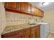 Functional laundry room featuring granite counters, tile backsplash, and upper and lower cabinets at 220 Coldeway Dr # 211, Punta Gorda, FL 33950