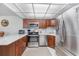 Well-lit kitchen with stainless steel appliances and warm wood cabinets at 2300 Aaron St # 106, Port Charlotte, FL 33952
