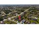 An overhead view showcases a residential neighborhood featuring mature trees, green spaces, and charming single-Gathering homes at 25199 Chiclayo Ave, Punta Gorda, FL 33983