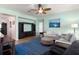 Inviting living room features a plush sofa, ceiling fan, and a built-in entertainment center at 25199 Chiclayo Ave, Punta Gorda, FL 33983