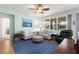 Bright living room featuring two sofas, a ceiling fan, and expansive windows at 25199 Chiclayo Ave, Punta Gorda, FL 33983