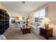 Cozy living room with plush seating, large windows, and a view into the dining area at 25199 Chiclayo Ave, Punta Gorda, FL 33983