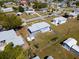 Aerial view of a property with a blue house, fenced in yard, and a gray roof in a neighborhood setting at 3124 Crestwood Dr, Port Charlotte, FL 33952