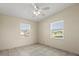 A neutral bedroom with tile floors, two windows, and a ceiling fan at 3124 Crestwood Dr, Port Charlotte, FL 33952