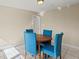 Small dining area with a round wooden table and four upholstered blue chairs at 3124 Crestwood Dr, Port Charlotte, FL 33952