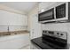 Modern kitchen with granite countertops, white cabinetry, stainless steel appliances, and bright lighting at 3124 Crestwood Dr, Port Charlotte, FL 33952
