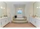 Luxury bathroom with a tiled tub, dual vanities, and elegant lighting at 333 Santander Ct, Punta Gorda, FL 33950