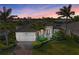 Gorgeous home features a well-manicured lawn, vibrant landscaping, and a paver driveway at sunset at 333 Santander Ct, Punta Gorda, FL 33950