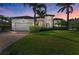 Beautiful home exterior featuring a well-manicured lawn, lush landscaping, and a paved driveway at 333 Santander Ct, Punta Gorda, FL 33950