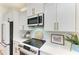Modern white kitchen with stainless steel appliances, granite countertops, and stylish backsplash at 333 Santander Ct, Punta Gorda, FL 33950