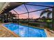 Relaxing screened-in pool with beautiful evening sky, overlooking a serene canal at 333 Santander Ct, Punta Gorda, FL 33950
