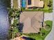 Bird's eye view highlighting a well-maintained house with a screened-in pool, a boat dock, and green landscaping at 3335 Grenada Ct, Punta Gorda, FL 33950